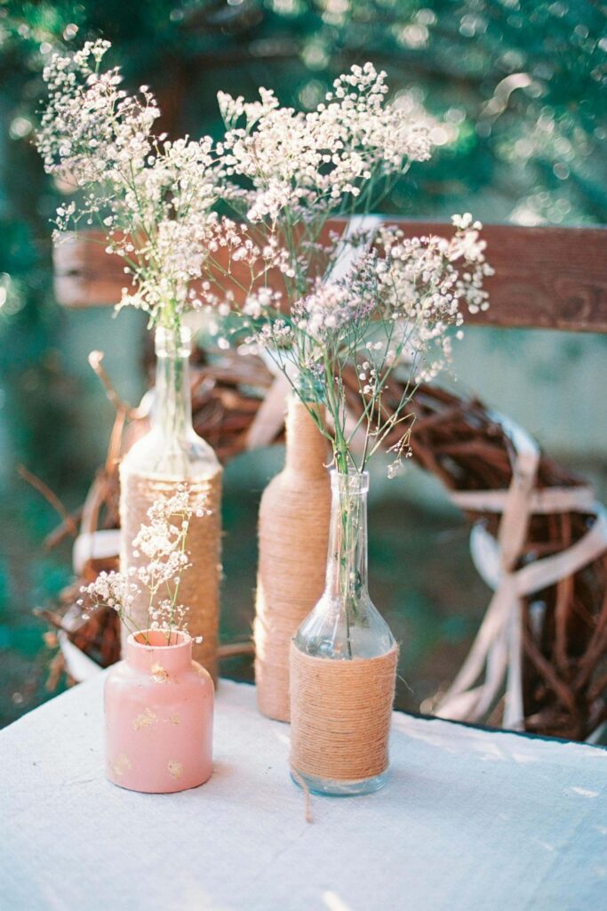 Friends gathered on a porch making May baskets surrounded by spring flowers and lemonade